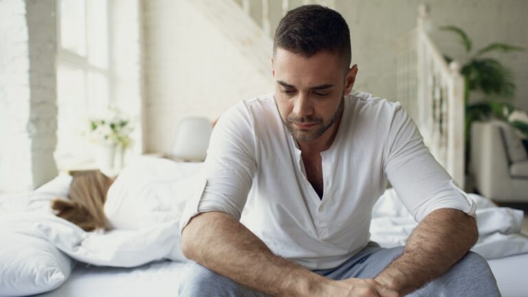 Man sitting on the edge of his bed with hip pain at night before treatment at Regenerative Joint Clinics in Riverdale, Georgia
